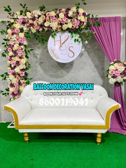 This beautiful engagement corner features a lush floral arch and a personalized sign with the couple's initials. The white sofa provides elegant seating for the couple.