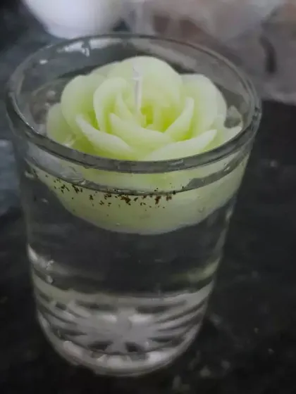 Another view of a rose candle floating in a glass of water. It's a simple way to add a touch of beauty and light to any corner of your home.