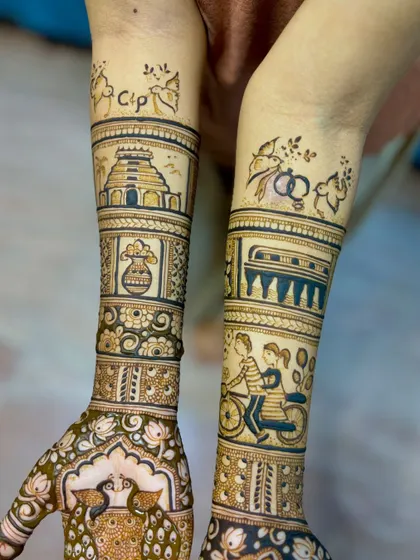 A close-up of the story elements on the forearms. One arm features a South Indian temple and kalash, while the other shows a couple on a bicycle and engagement rings.