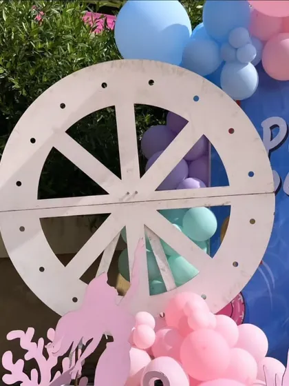 A close-up of the large ship's wheel prop, adding a nautical touch to the pre-wedding celebration.