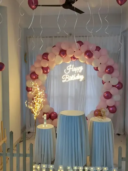 A minimalist and romantic home setup with a pink and white balloon ring and sheer curtain backdrop.