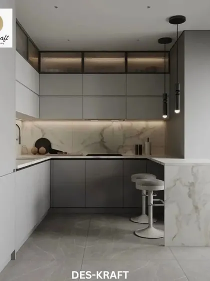 This U-shaped kitchen is a model of modern efficiency, featuring matte grey handleless cabinets, a white marble backsplash and countertop, and a breakfast bar for casual dining.