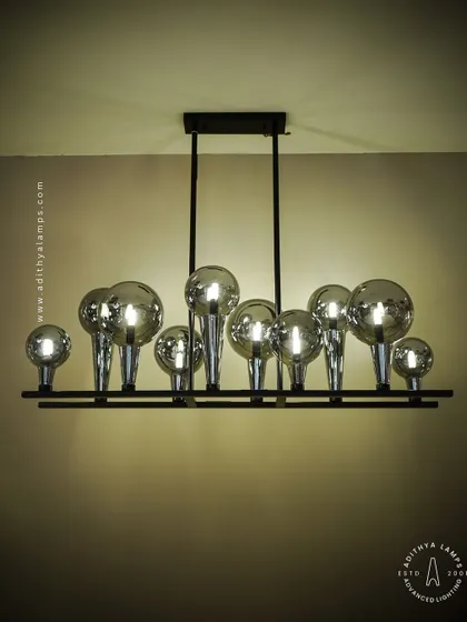 A playful yet chic linear chandelier featuring a series of chrome-finished glass bubbles. The highly reflective surface and modern design make it a striking addition to a kitchen island or a contemporary dining space.