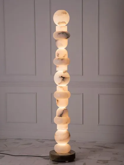 A totem-style floor lamp made from stacked pieces of marble. This is a true statement piece, combining sculpture with functional lighting.