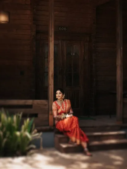 A dreamy, soft-focus portrait of the bride sitting on the steps of a wooden cabin.