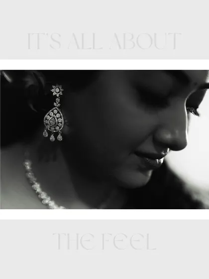 A close-up, artistic black and white portrait of the bride. The focus on her earring and serene profile highlights her elegance and the fine details of her look.