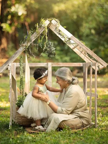 A first birthday shared with a grandmother is extra special. This whimsical outdoor setup with a tiny house prop created a truly magical memory.