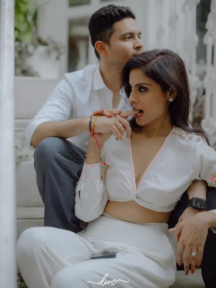 A candid and playful moment on the steps, this pre-wedding shot captures the fun and flirty chemistry between the couple.