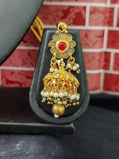 A small, delicate temple-style jhumka with a floral top and pearl drops. This rental earring is perfect for a simple, traditional look.