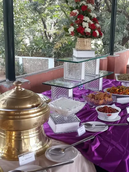 An elegant buffet arrangement with a purple and gold theme for a special celebration. The setup includes our ornate golden serving dishes and tiered glass stands for a touch of luxury.