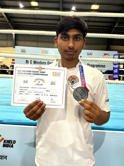 A close-up of our boxer with his certificate of merit and bronze medal from the REC Open Talent Hunt Program.