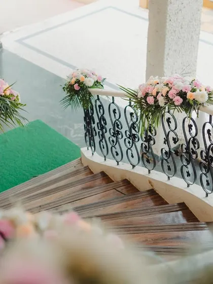 The staircase leading to the Mehendi celebration was adorned with beautiful bouquets of pink and white roses, creating a dreamy and romantic entrance.