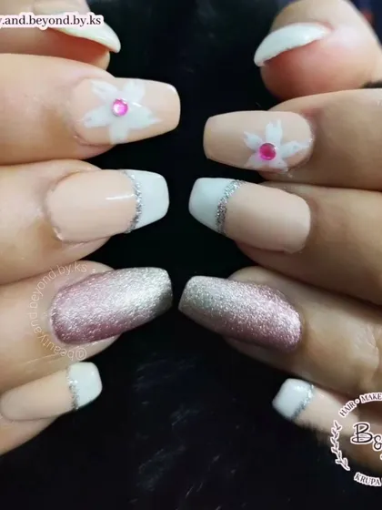 A detailed macro shot showing the precision of the silver glitter line on the French tips and the delicate floral art.