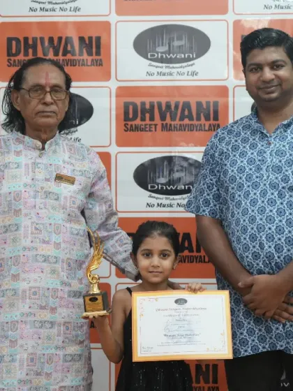 A student with her father and guru, celebrating her achievement.