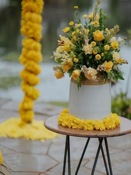 A beautiful floral centerpiece with yellow roses and lilies, part of a cohesive yellow-themed decor.