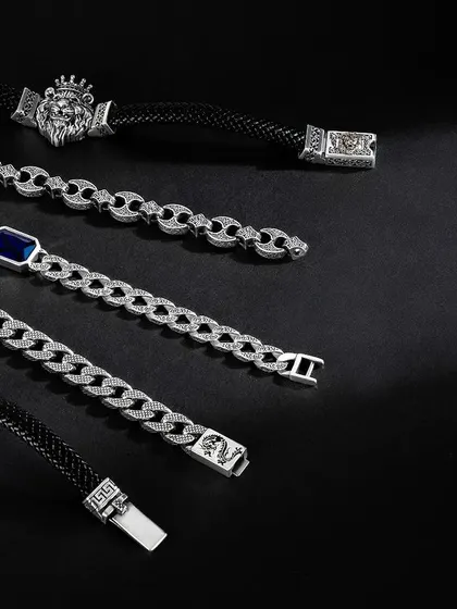 A flatlay showcasing a variety of men's bracelets from Orionz Jewels. The dark, moody lighting and clean arrangement on a black background give the collection a cohesive and premium feel.