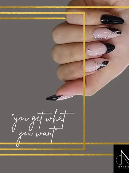 A sophisticated and edgy French manicure. This design uses a sharp, pointed black tip on an almond-shaped nail, with delicate silver glitter lines for added dimension.