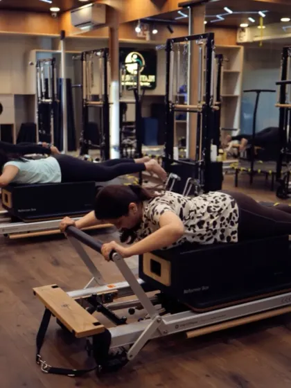 The Swan Dive on the Reformer is an excellent exercise for strengthening the back extensors and opening the chest. Here, clients perform the move in sync, showcasing control and coordination.