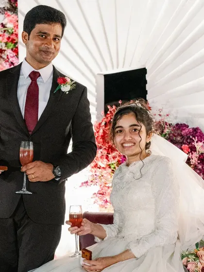 A happy toast from the couple during their reception. The vibrant floral backdrop adds a celebratory feel to this candid moment.