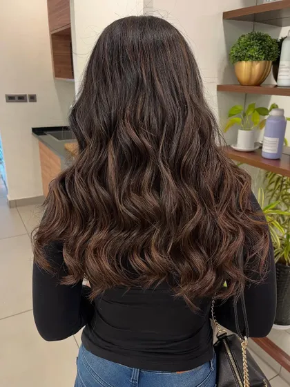 A full view of a mocha brown balayage, showing how the color looks against the salon's bright background.