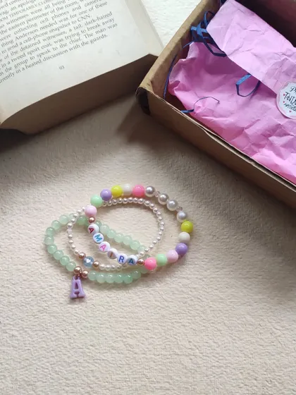 A personalized bracelet stack for Amara, shown next to its gift box. We use a mix of green jade, pearls, and pastel beads.