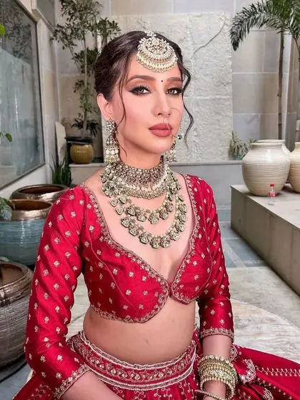 A beautiful portrait of the bride, with a focus on her serene expression and the stunning bridal jewelry.