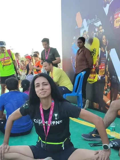 A team member takes a moment for a seated wide-legged stretch. This pose targets the inner thighs and hamstrings, areas that need attention in every runner's flexibility routine.