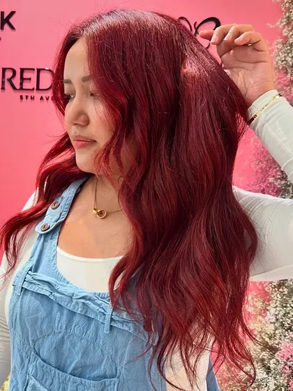 A vibrant, fiery red created with Redken color. This look is bold, confident, and full of personality.