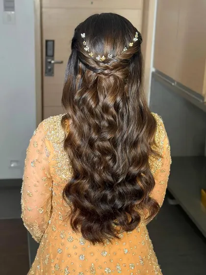 A detailed shot of this half-up, half-down hairstyle with soft waves and delicate butterfly clips. It's a luxurious and timeless look.