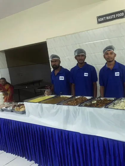 Our team stands proudly behind a well-stocked buffet, ready to welcome guests.