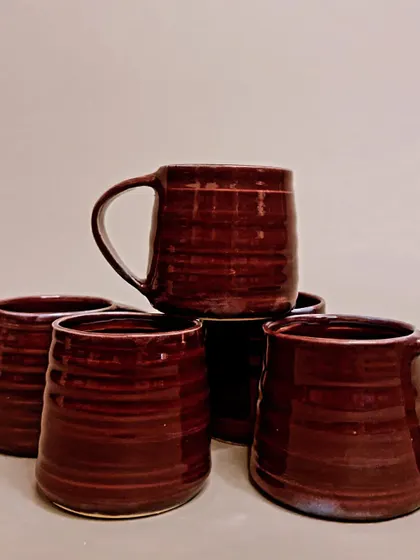 A collection of my rich, burgundy-glazed mugs and tumblers. Each piece is a unique work of art, perfect for elevating your morning routine with a touch of handmade beauty.
