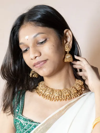 A beautiful profile of our customer wearing the temple jewellery set. You can see the detailed work on the jhumkas and the choker.