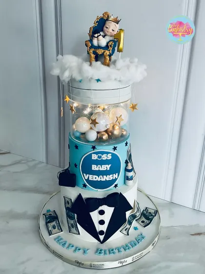 This adorable Boss Baby cake for Vedansh's first birthday features a light-up middle tier and a baby on a throne topper, making it a truly special cake.