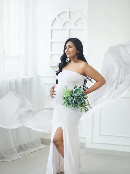 A solo portrait celebrating the mother-to-be. The flowing white fabric adds a touch of ethereal grace to this powerful moment.