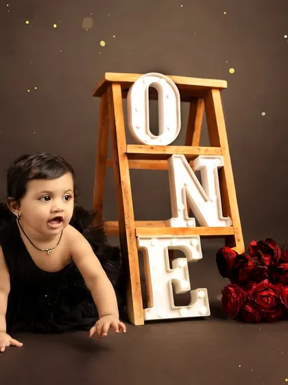 A candid shot of the birthday girl crawling, capturing her movement and curiosity during the session.
