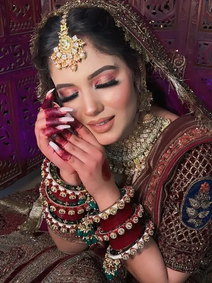 The same bride with her eyes closed, showing off the delicate pink and gold eyeshadow. This is a perfect example of a soft glam bridal eye look.