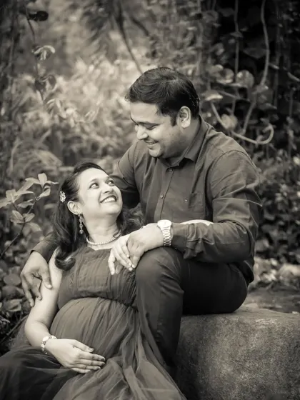 A joyful black and white portrait. The genuine smiles and laughter between this expecting couple are the focus of this timeless and happy image.
