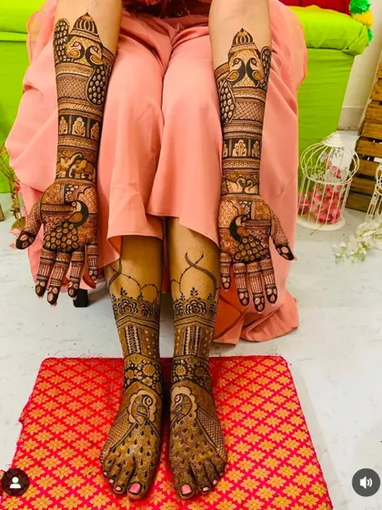 This full-body shot shows how the hand and feet mehndi come together. The design is rich with peacock motifs, creating a graceful and unified look from top to bottom.