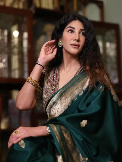 Dressed in a traditional emerald green saree. This jewel tone is a classic choice that is universally flattering for cool undertones and perfect for formal events.