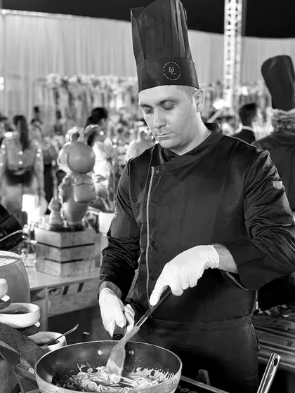 In this focused, black and white shot, our chef is completely absorbed in the process of creating a dish. It captures the artistry and concentration required to perfect every plate we serve.