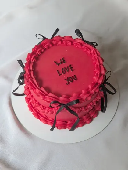 A bold and beautiful vintage cake in red and black. The piped ruffles and delicate ribbons give it a classic, dramatic look.