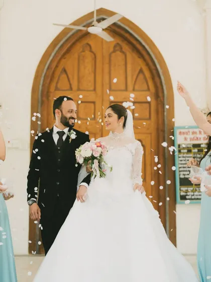 The couple's joyful exit from the church, showered with confetti by their loved ones. This photo is full of movement, happiness, and celebration.