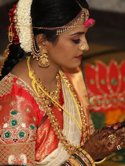 A side profile of the beautiful bride Madhura, with the rich stain of her mehendi visible on her hands and arms.