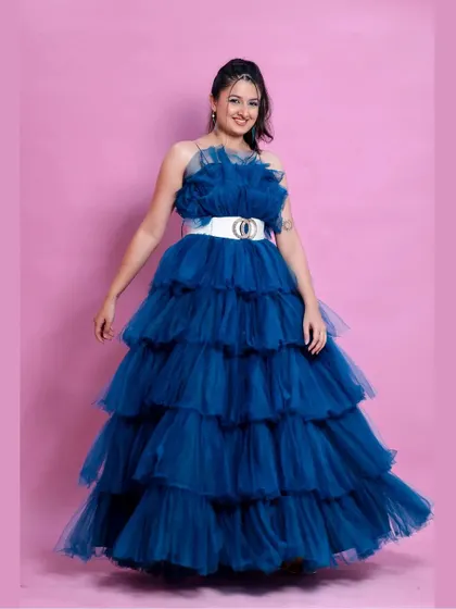 A full-length shot showing the beautiful tiered ruffles of the peacock blue gown.