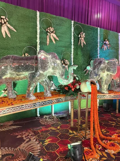 Another look at our mirrored elephant props, this time against a green hedge wall, showing their versatility in different decor settings.
