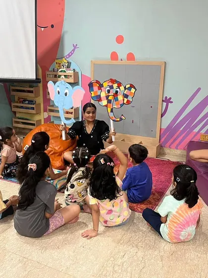 Story time with Elmer the Elephant. Using puppets makes the story interactive and helps children connect deeply with the characters and the narrative.