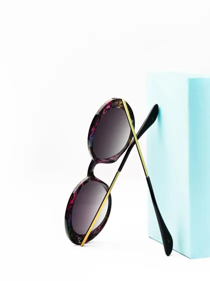 A clean, high-key product shot of sunglasses against a light blue block. This is a perfect example of a simple, effective image for an e-commerce website or catalog.