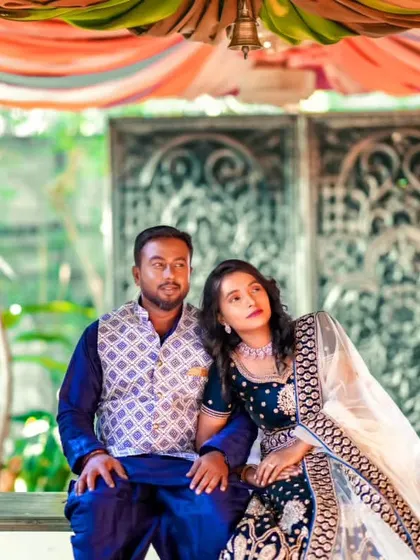 A beautifully framed shot of the couple on a swing. The traditional outfits I provided look stunning against the colourful, festive backdrop.
