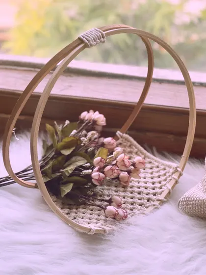 A unique macrame magazine or book holder. The double-hoop design creates a stylish sling to keep your reading material organized and accessible.
