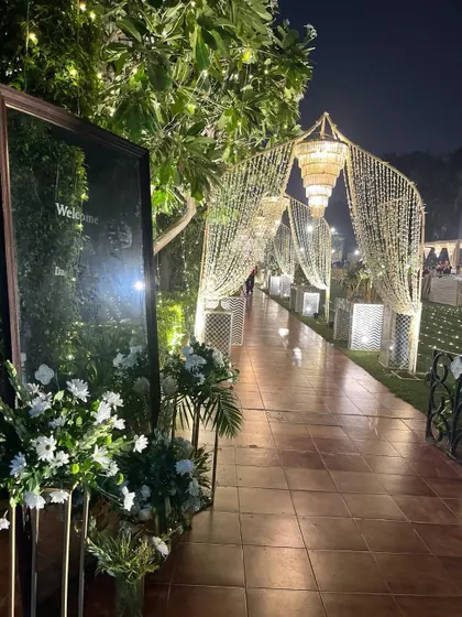 A magical entrance pathway for a Sufi-themed night. Arched structures draped in strings of lights create a grand and warm welcome for guests.